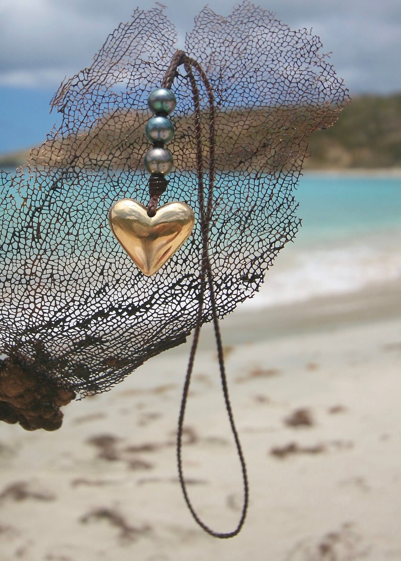 18K gold heart necklace with Tahitian pearl on leather cord, St Barth beach