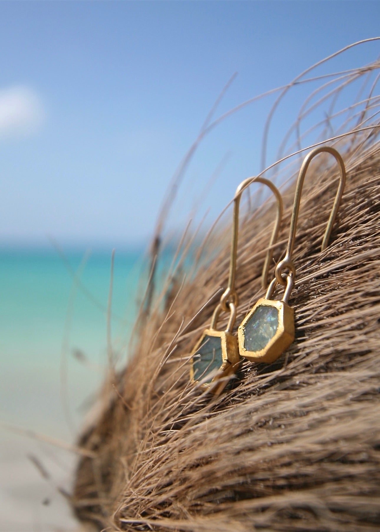 Handmade emerald gold hexagon earrings on palm fiber, Caribbean turquoise sea
