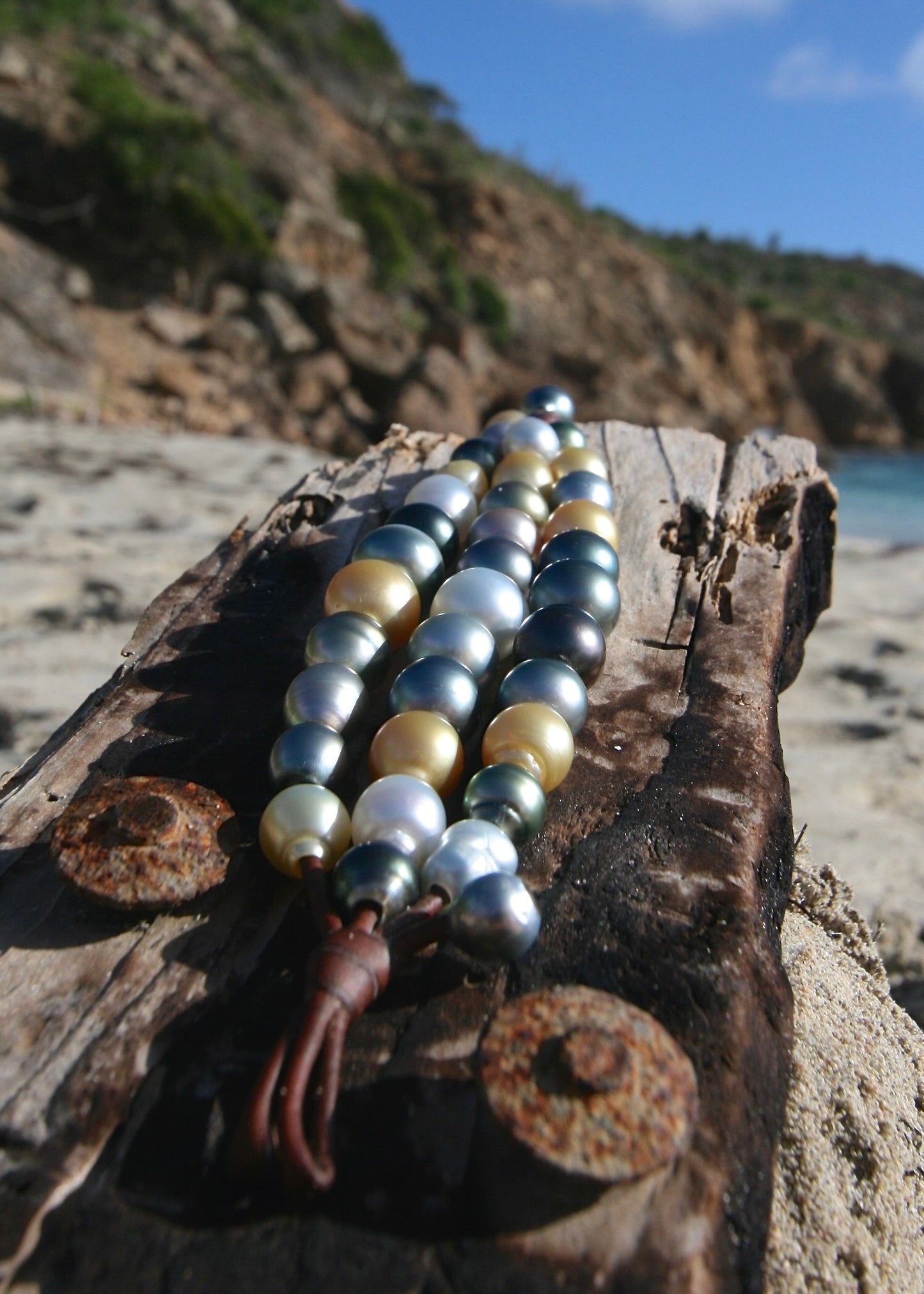 Tahitian and golden pearl leather bracelet on driftwood, St Barth hillside