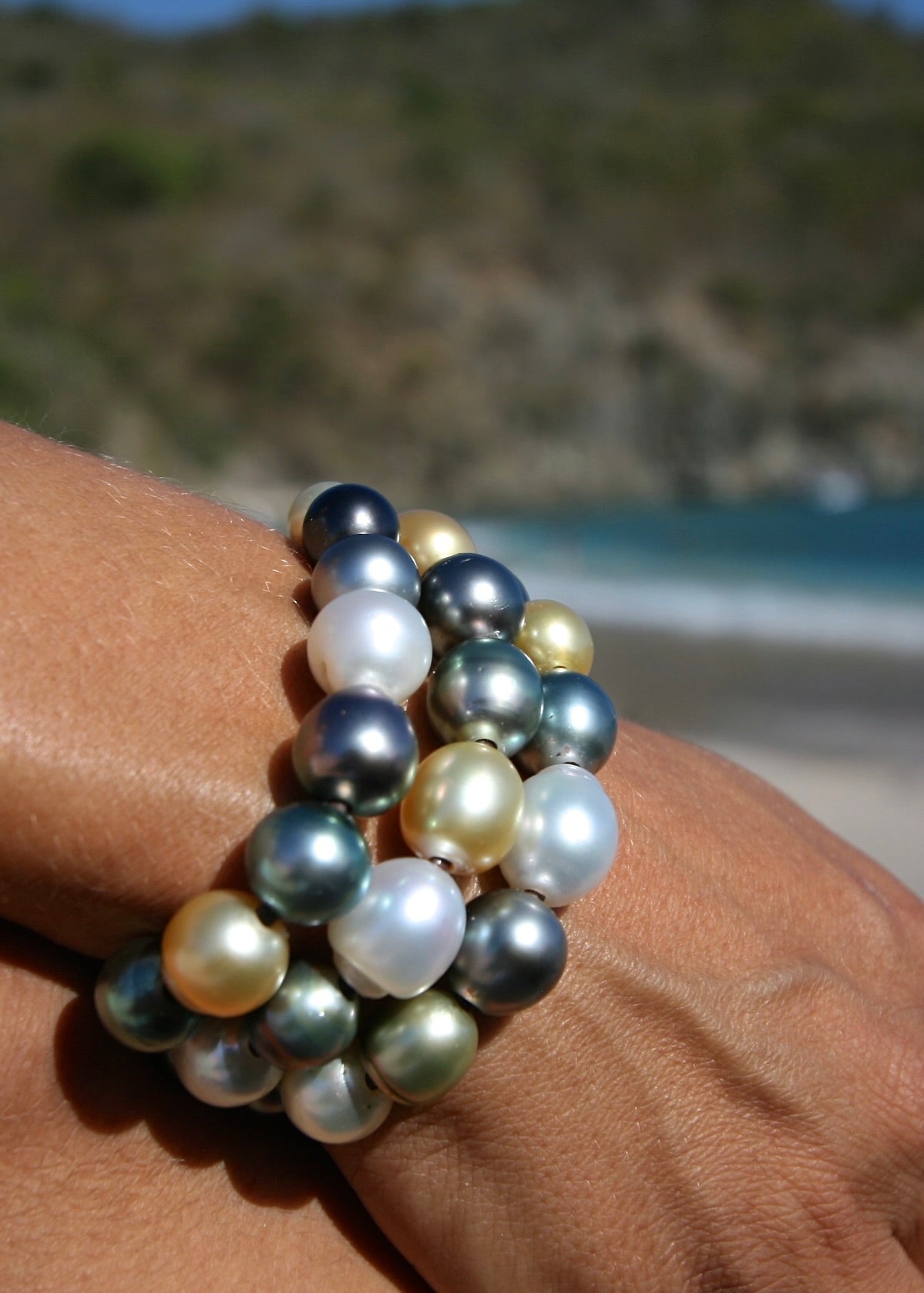 Multicolor pearl leather cuff bracelet worn on wrist, island setting