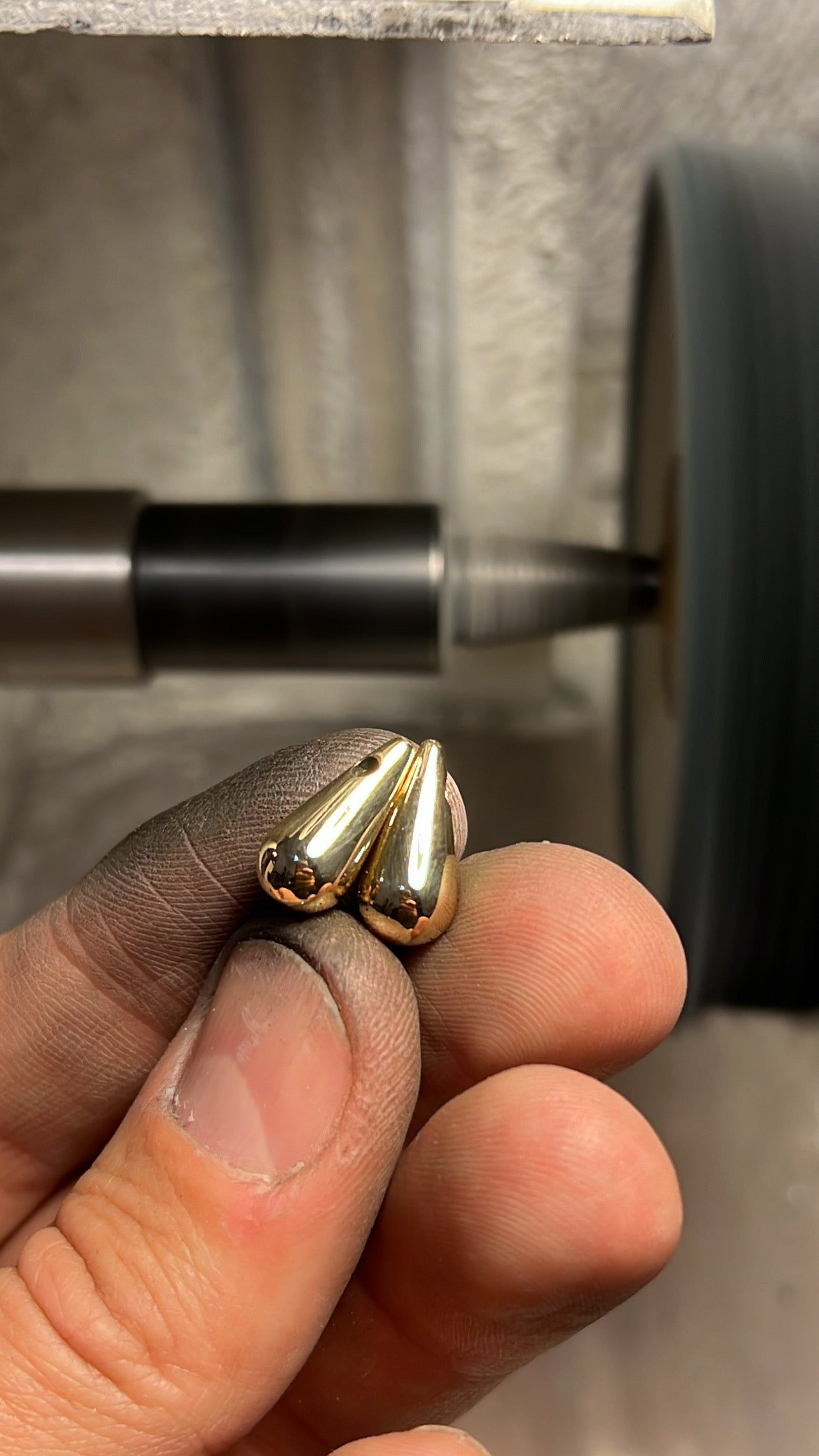 Solid 18K gold drop earrings held in hand, freshly polished workshop Montreal