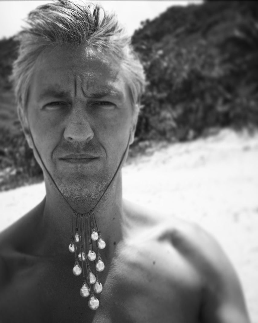 Black and white portrait of Ted Deltour wearing a long Tahitian pearl necklace