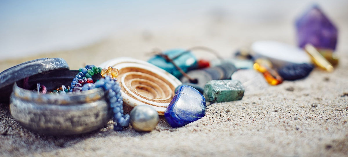 Handmade jewelry, beads, and gemstones from Trésors de St Barth displayed on a St. Barth beach
