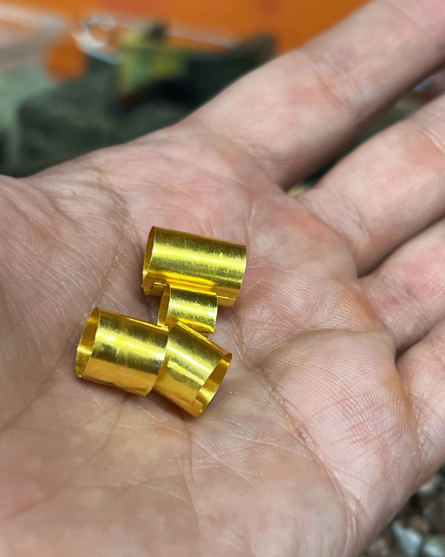 Hand-cut 24K gold tube beads held in palm, jewelry workshop Montreal