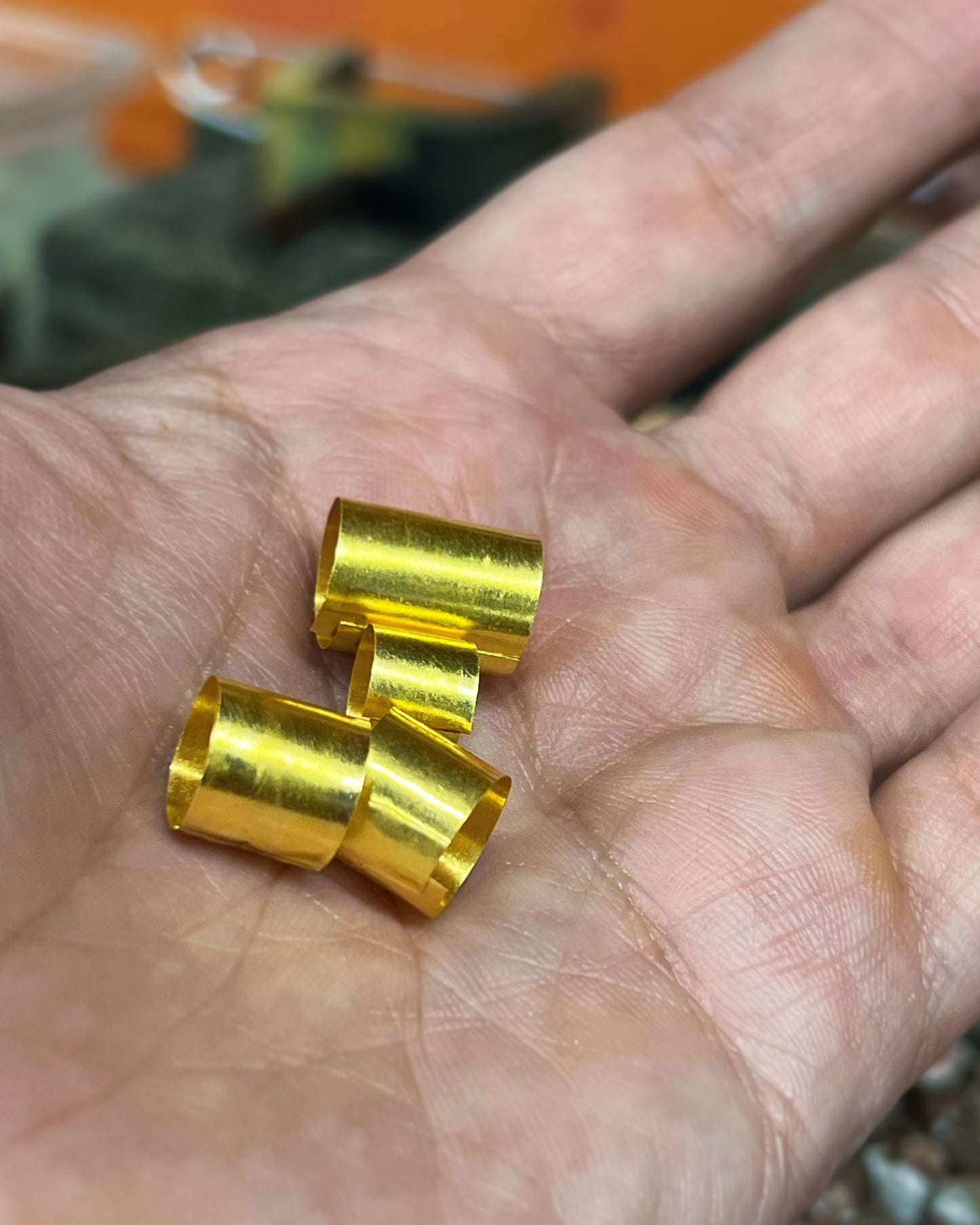 Hand-cut 24K gold tube beads held in palm, jewelry workshop Montreal