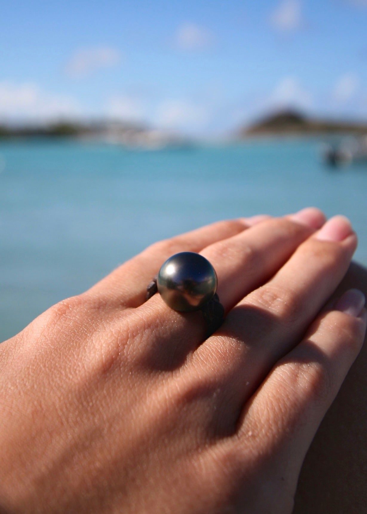 Trésors de St Barth Tahitian pearl leather ring worn on hand, Caribbean sea
