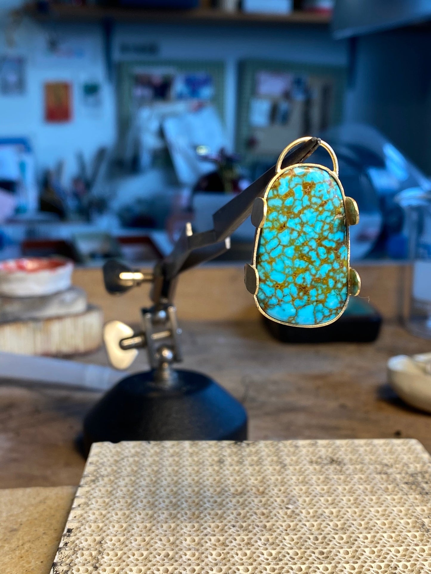 Nevada spiderweb turquoise stone mounted on jeweler's vise, Montreal atelier