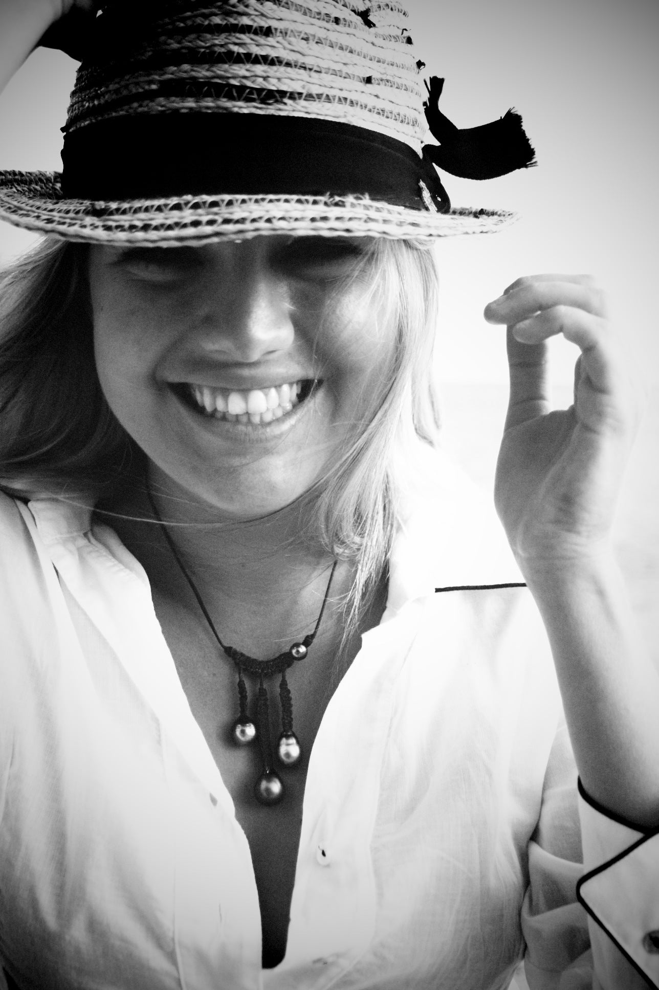 Black and white smiling portrait with pearl and macramé pendant necklace