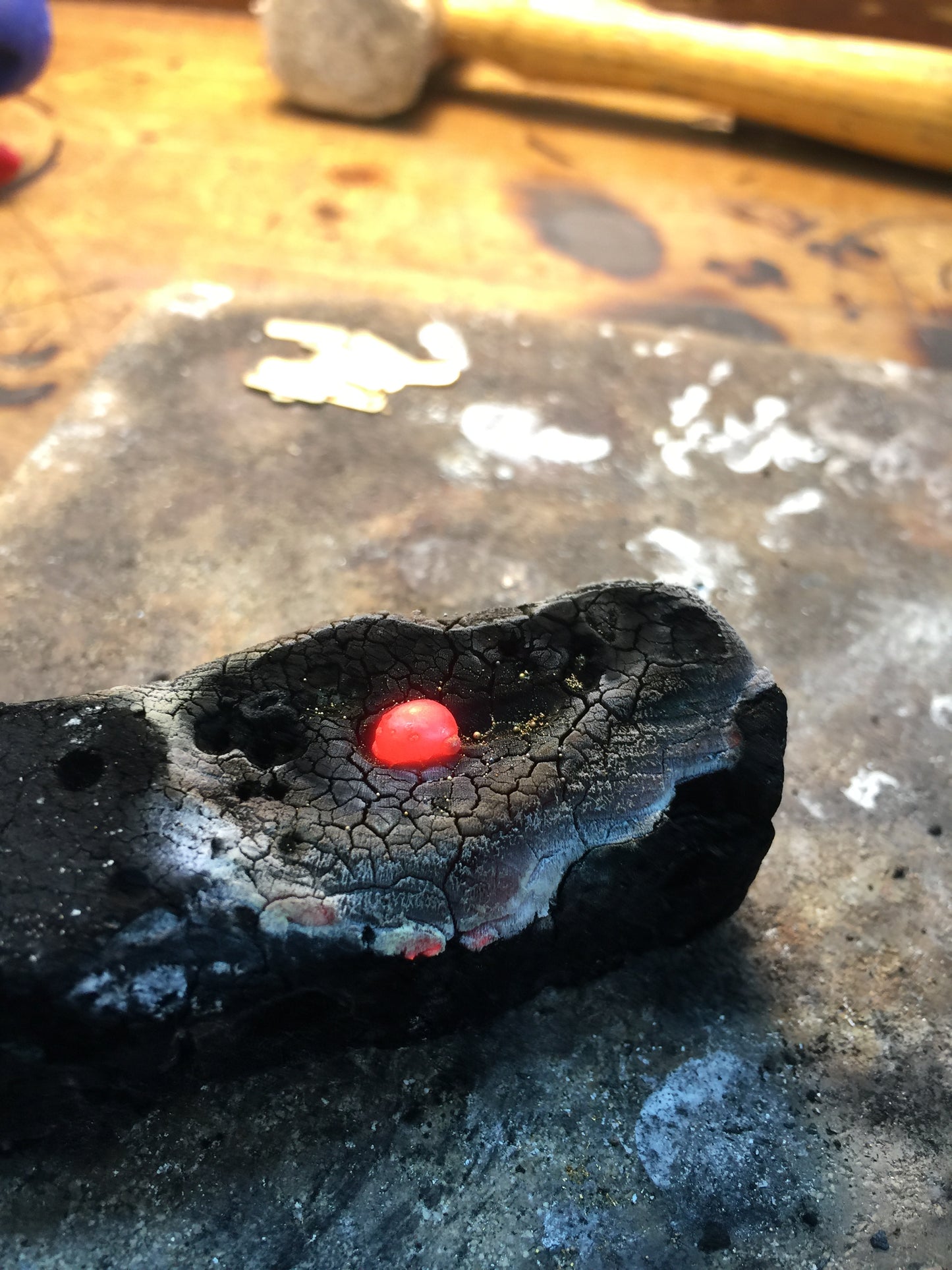 24K gold casting in progress, molten metal in workshop crucible