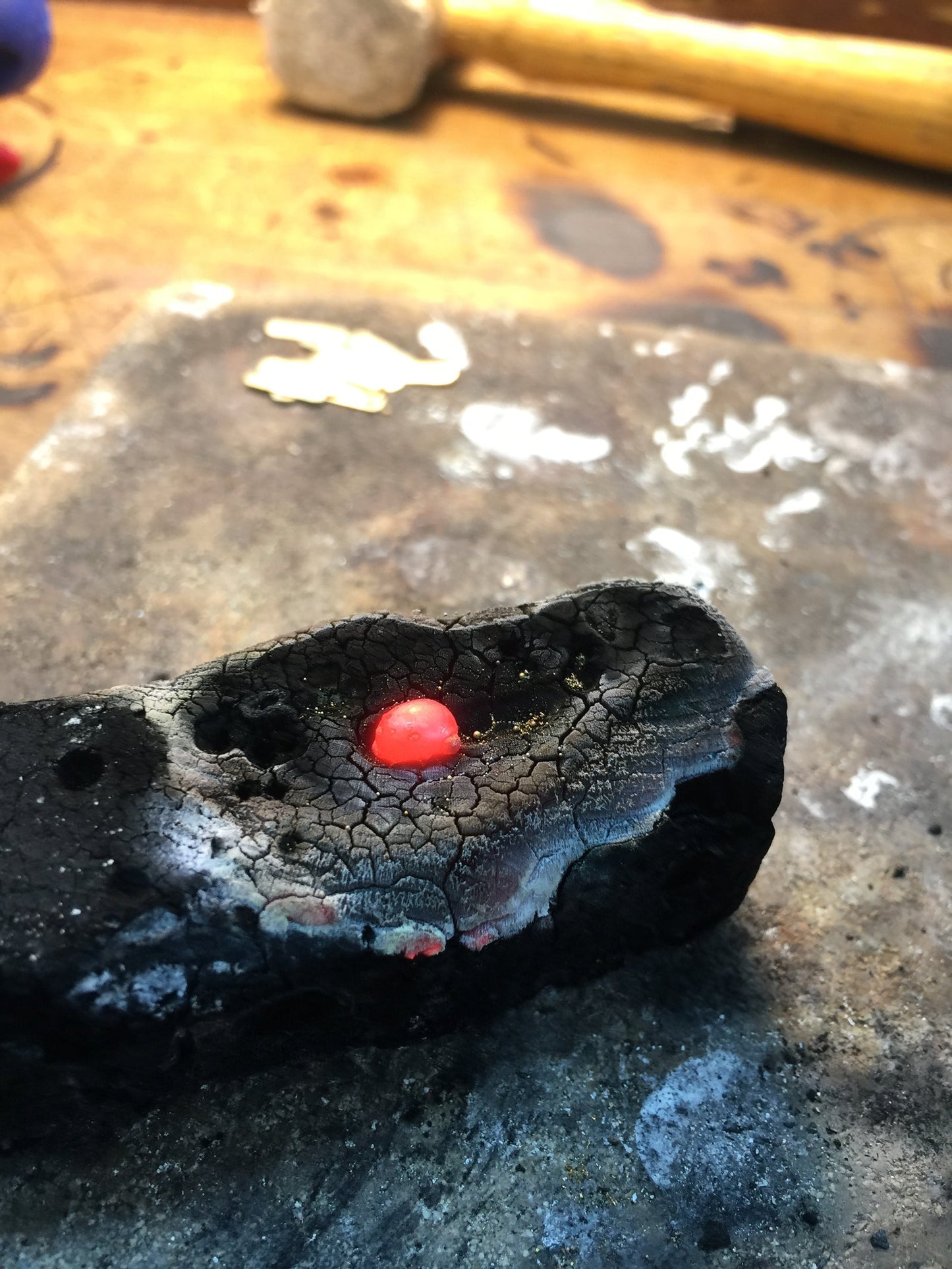 24K gold casting in progress, molten metal in workshop crucible