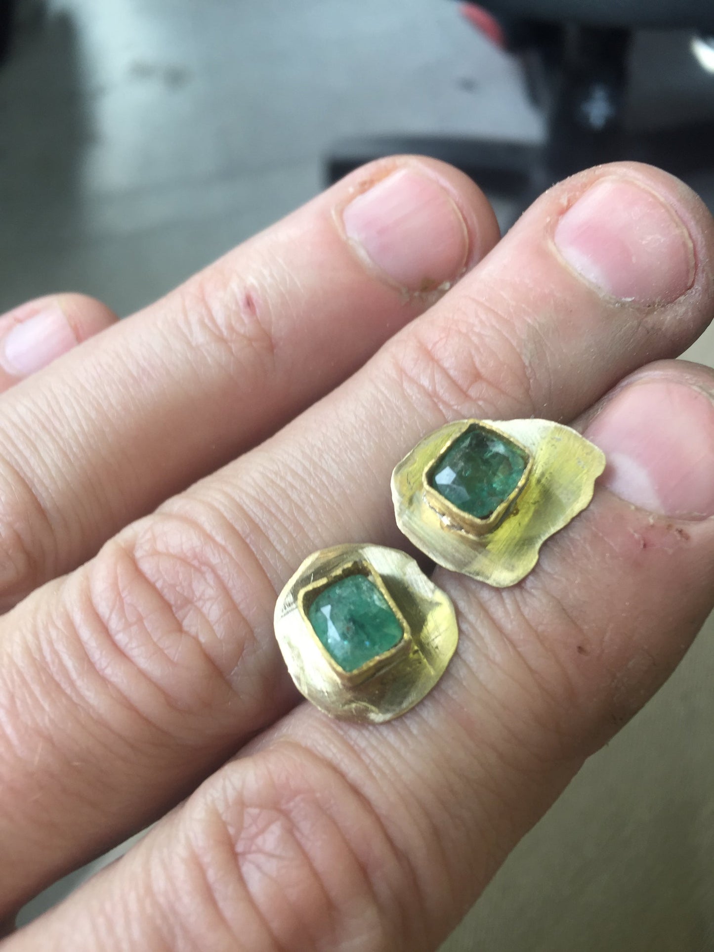 Raw emerald set in 24K gold bezel, handmade earrings in progress workshop