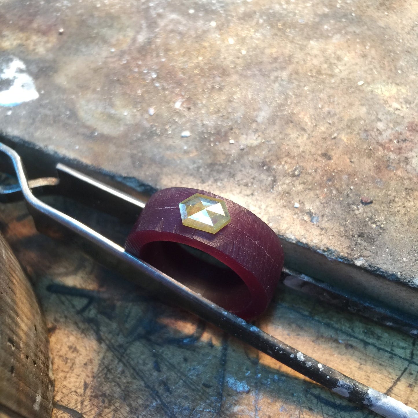 Diamond-set wax ring model in jeweler's tweezers, lost wax casting process