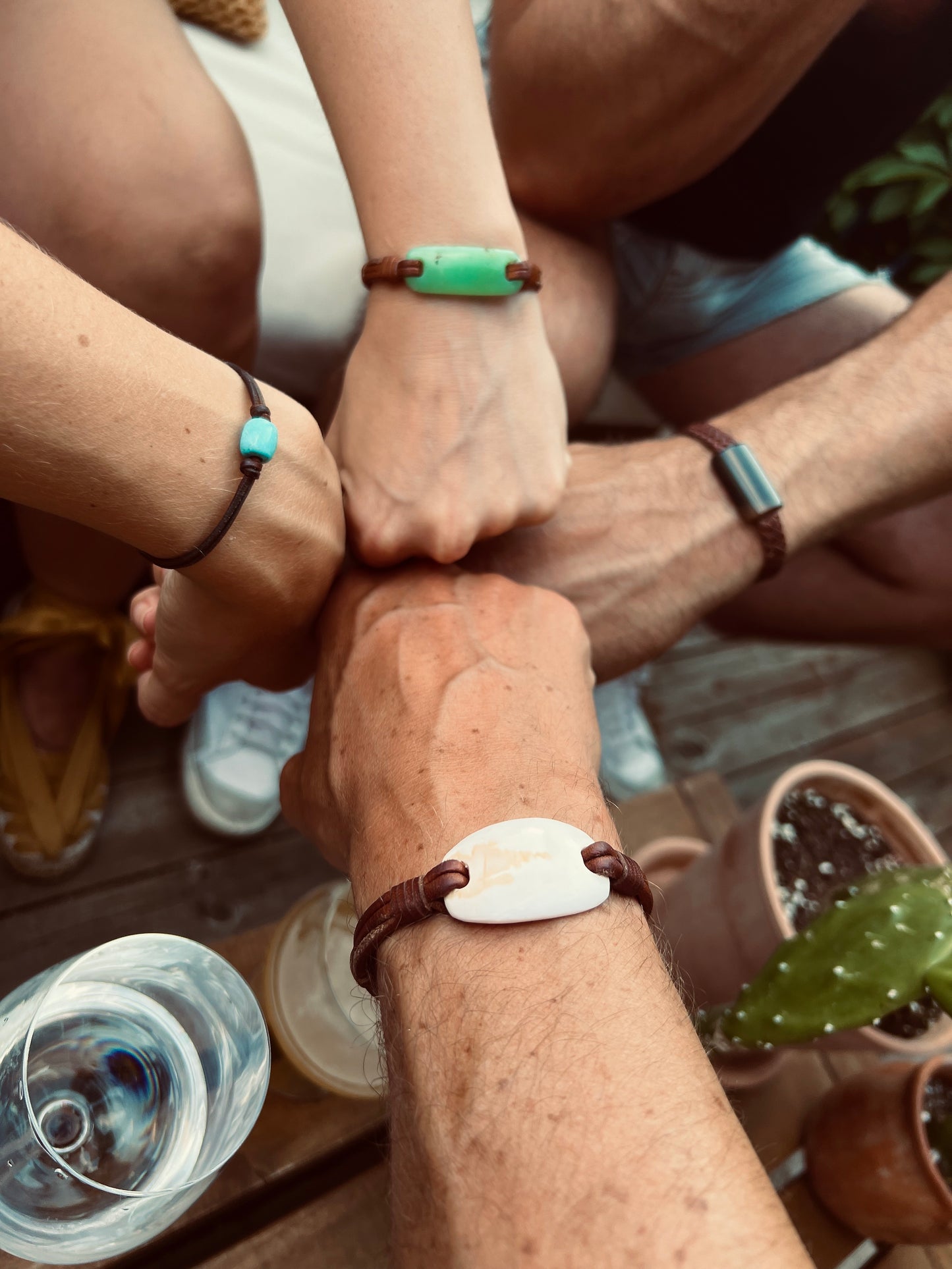 Joined hands wearing kangaroo leather bracelets and natural stone beads
