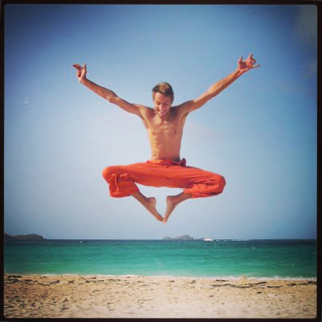 Ted Deltour jumping for joy on the beach, free creative spirit