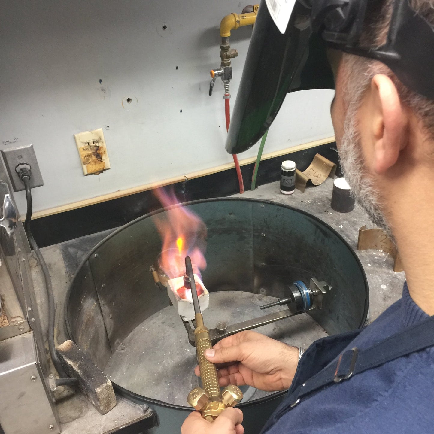 Ted Deltour soldering gold jewelry with torch, Montreal jewelry atelier