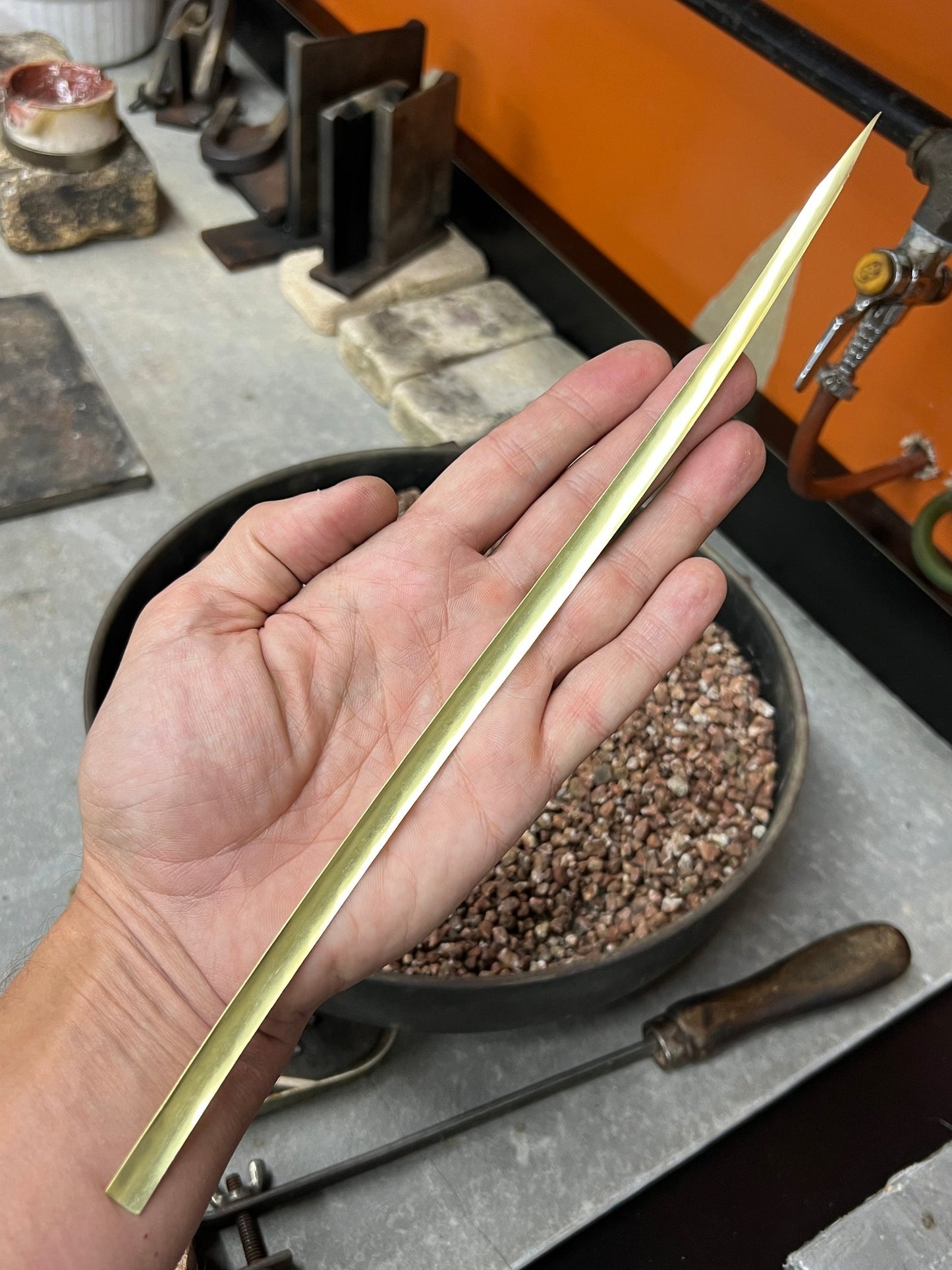 Solid 18K gold bar held in hand, Trésors de St Barth workshop