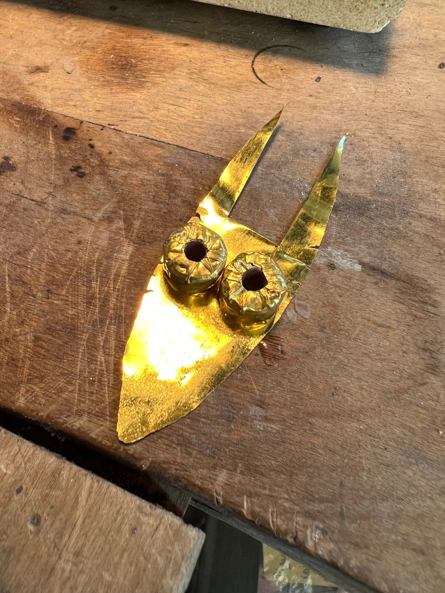 Solid gold brooch in progress on workbench, jewelry workshop Montreal