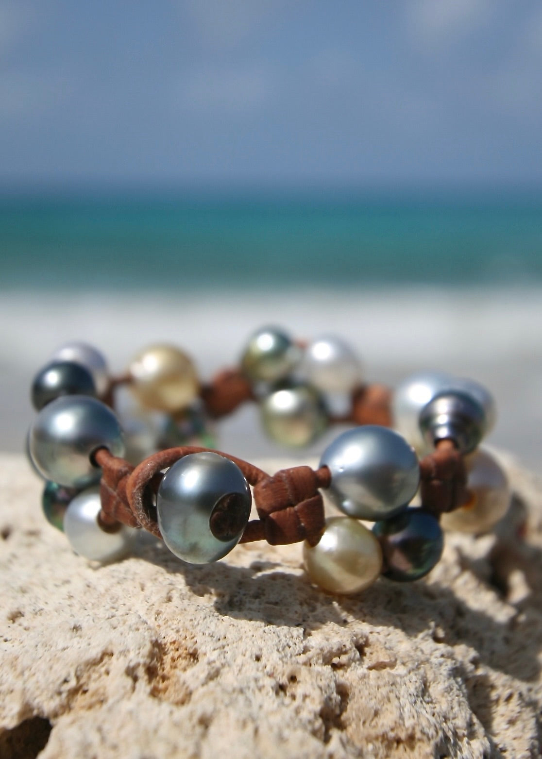 Tahitian golden and silver pearl cluster bracelet on rock, St Barth beach
