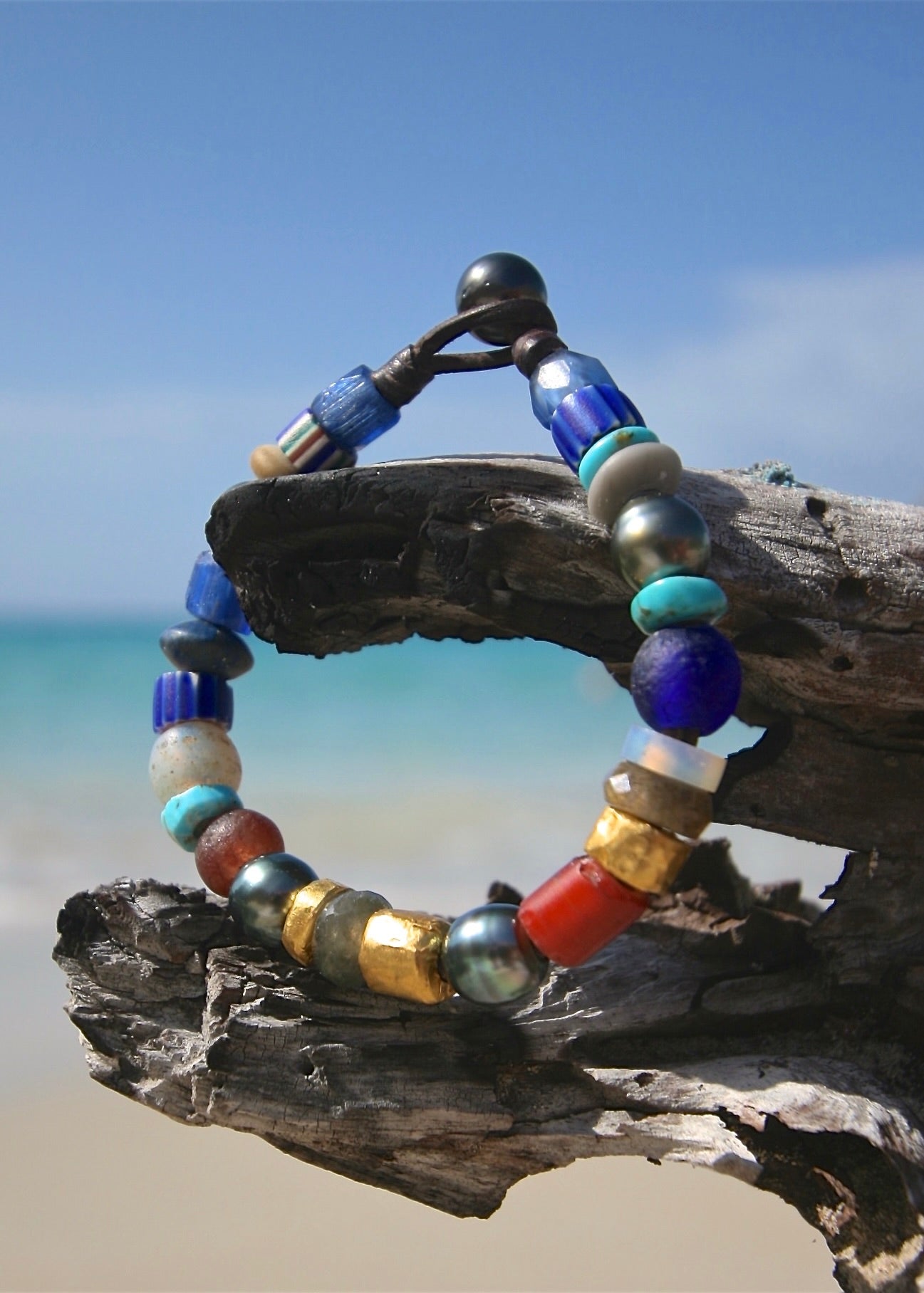 Trésors de St Barth rare African bead 24K gold bracelet on driftwood, Caribbean