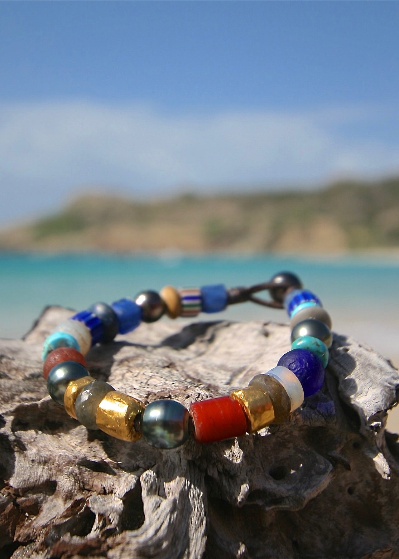 24K gold and African trade bead treasure bracelet on driftwood, St Barth beach