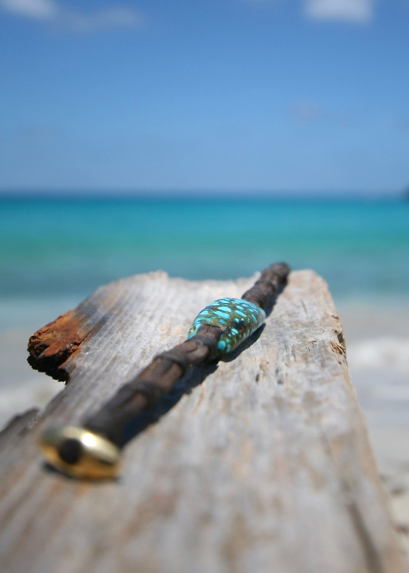 Rare spiderweb turquoise leather bracelet on driftwood, Caribbean turquoise sea