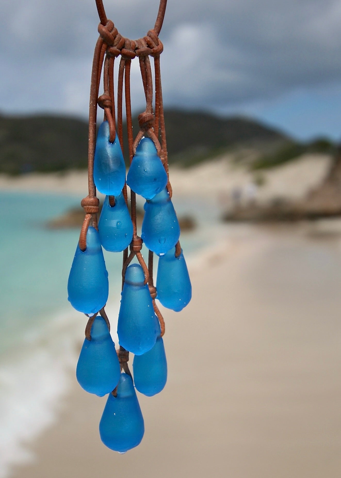 Full view of twenty hand-sculpted crystal glass drops knotted on kangaroo leather with sea glass finish