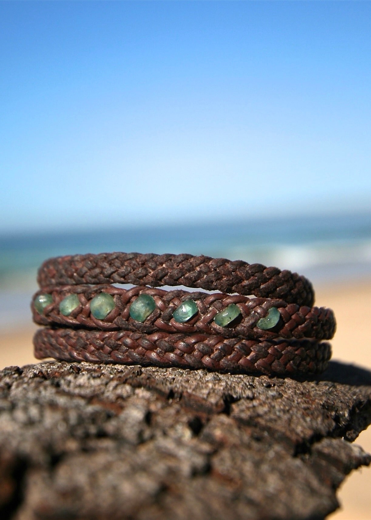Triple wrap emerald bracelet on hand-woven kangaroo leather showing seven faceted emerald beads on rock