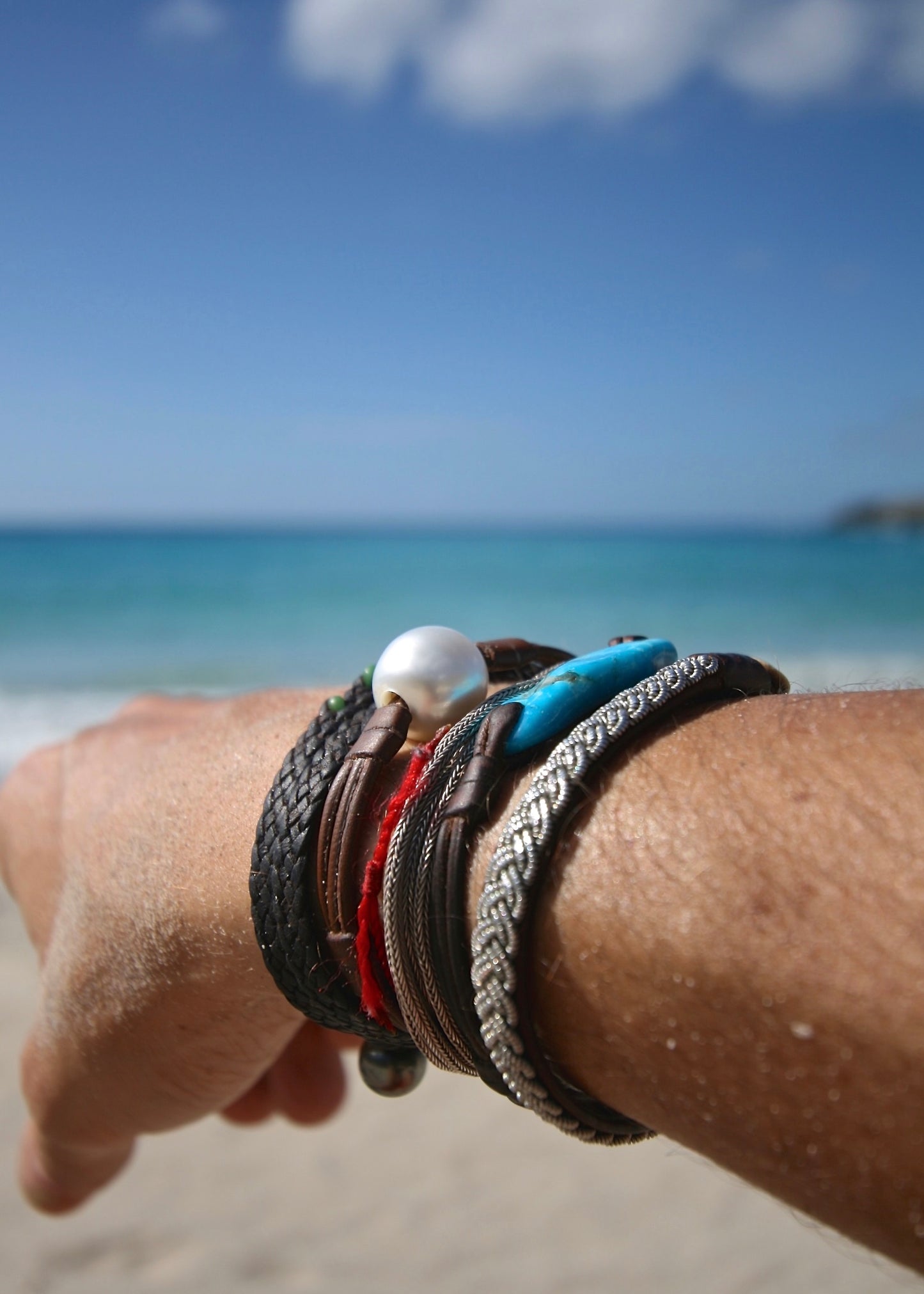 Trésors de St Barth large Australian pearl leather bracelet worn on wrist, Caribbean sea