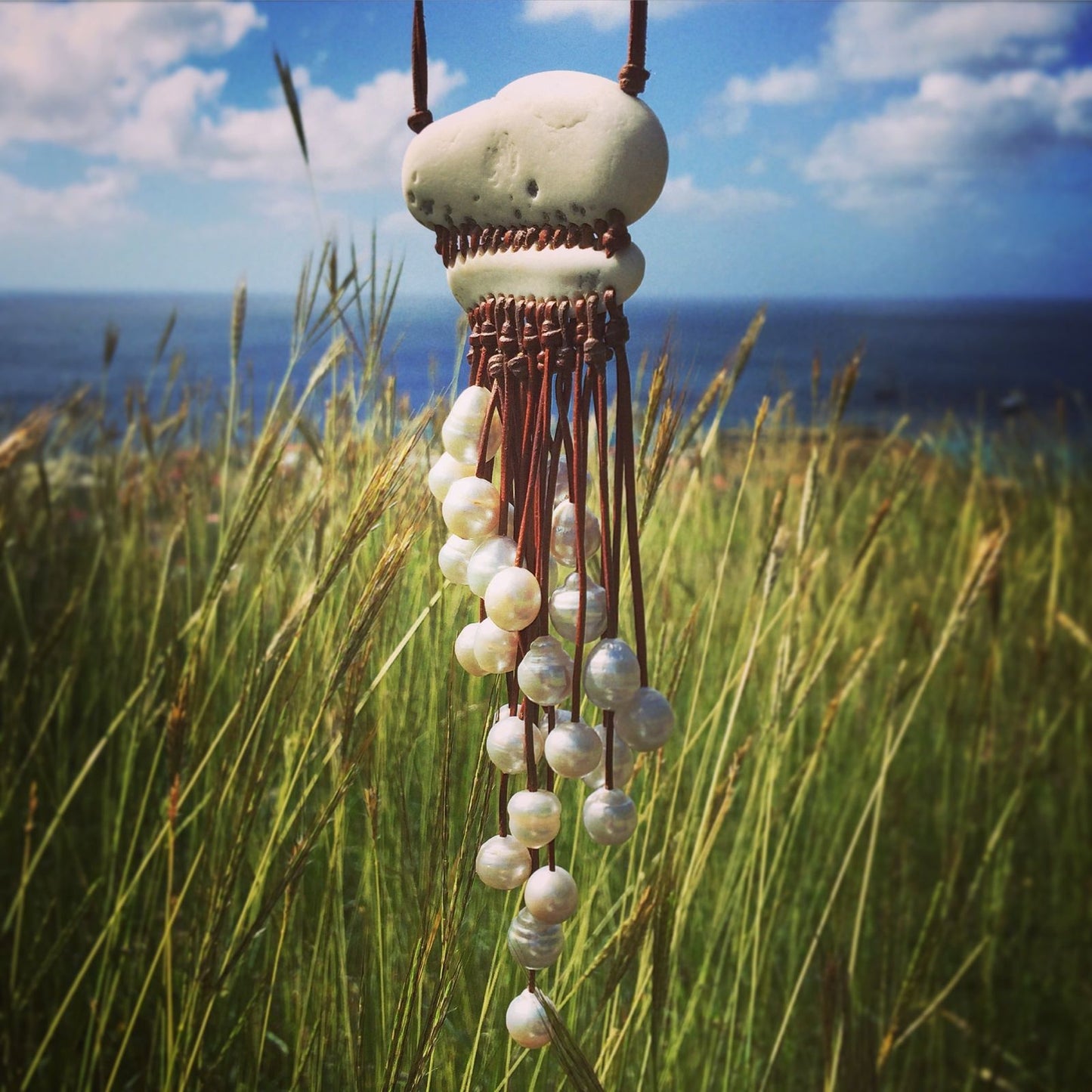 Shell pendant necklace with cascading pearl fringe outdoors, one of a kind jewelry St Barth